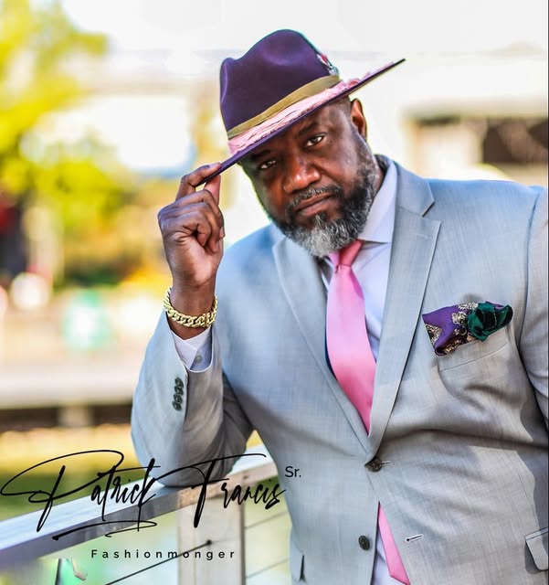 Patrick Francis Sr. in a grey suit and wide-brim hat