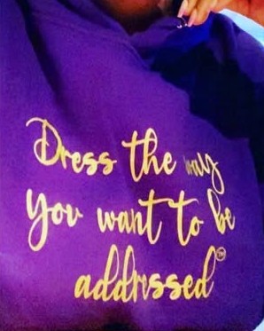 Purple hoodie printed with Dress the way you want to be addressed in gold script
